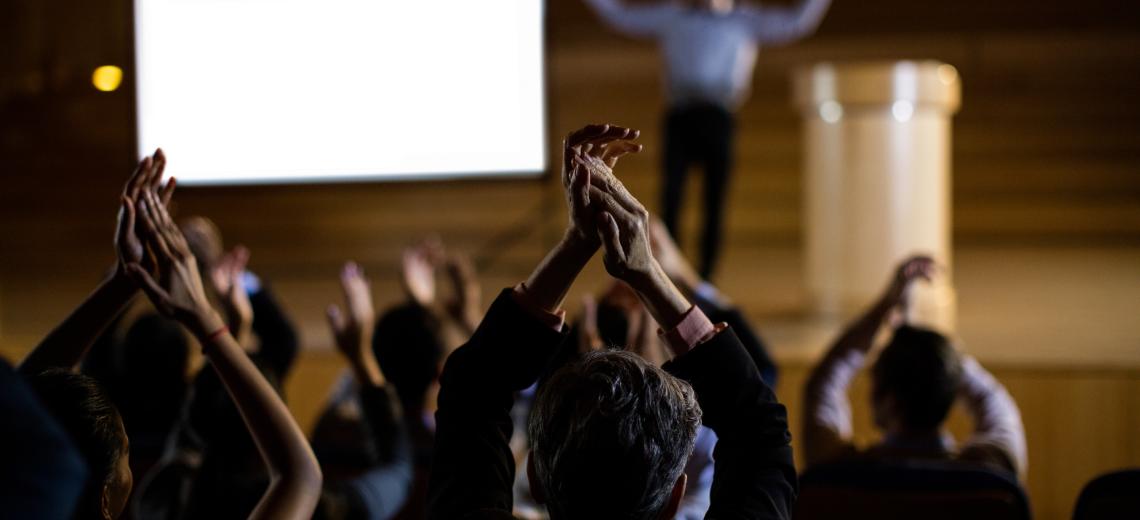 Audience applauding speaker after conference presentation © Freepik