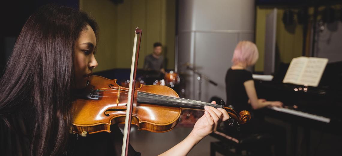 Two female students playing violin and piano