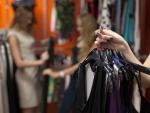 Woman holding bunch of garments in shop, closeup © freepik