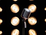 Silver microphone on stage in illuminated studio. © Freepik