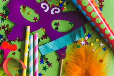 orange-feather-with-purple-mask-confetti © Freepik