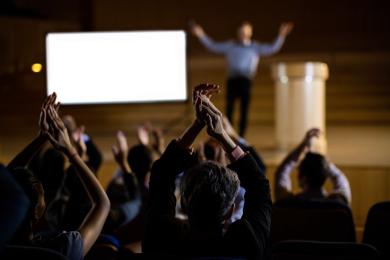 Audience applauding speaker after conference presentation © Freepik